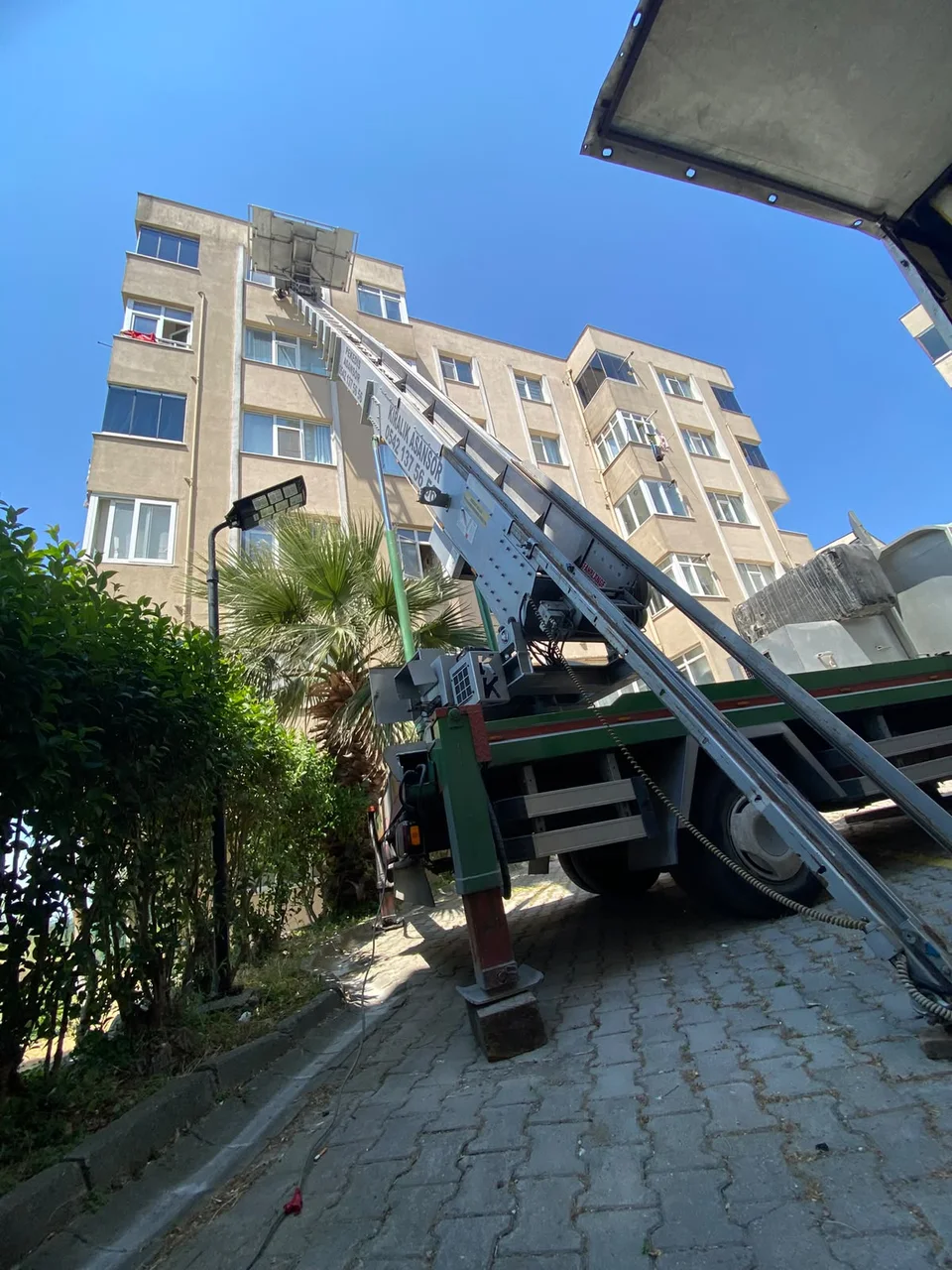 Dış cephe asansörüyle binadan eşya çıkarma çalışması